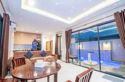Modern open-plan living room with pool view and stylish furniture