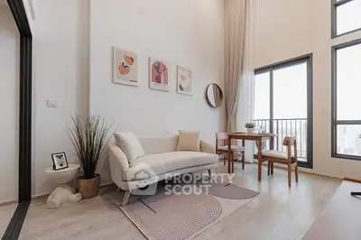 Modern living room with stylish decor and large windows offering natural light.