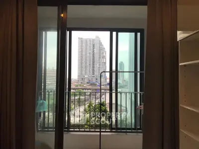 Modern apartment balcony with city view and sliding glass doors.