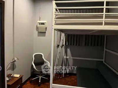 Compact bedroom with loft bed and study area, ideal for maximizing small spaces.