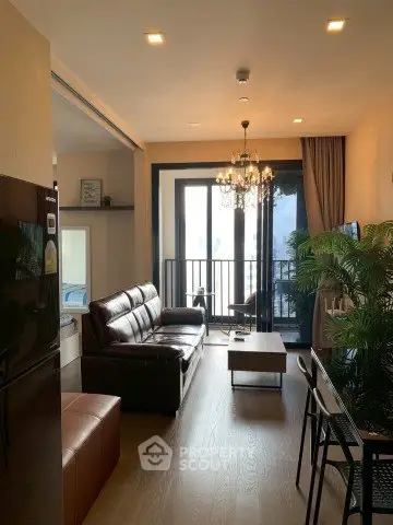 Stylish living room with elegant chandelier and balcony view in modern apartment