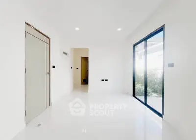 Spacious modern living room with large windows and sleek white flooring