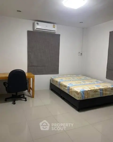 Spacious bedroom with modern furniture and air conditioning, perfect for comfort and relaxation.