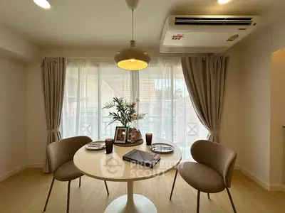 Chic dining area with modern decor and natural light in a stylish apartment.