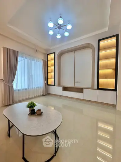 Spacious modern living room with elegant lighting and large window, perfect for relaxation and entertainment.