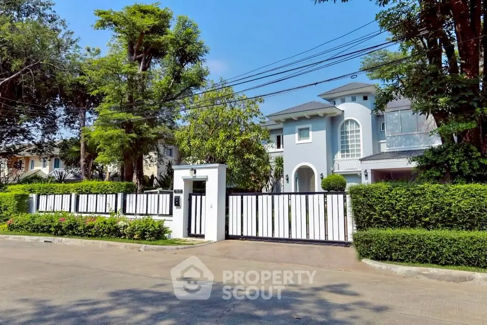 Luxurious white villa with elegant entrance and lush greenery