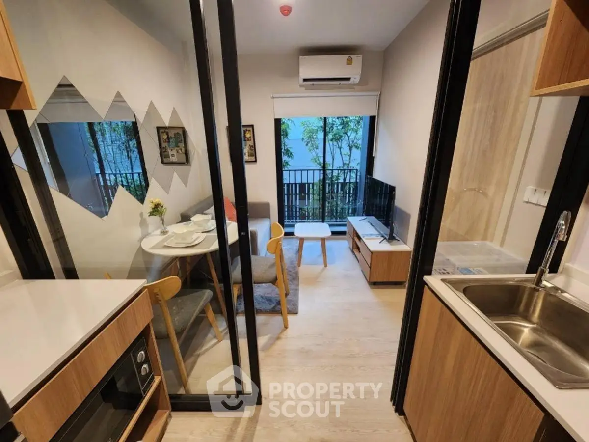 Modern compact living room with balcony view and stylish kitchen area