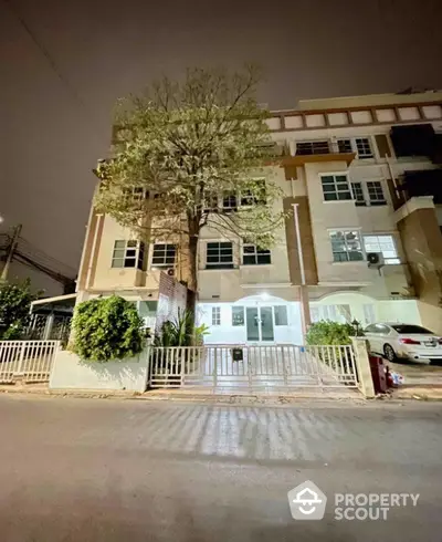 Charming townhouse exterior with gated entrance and lush greenery