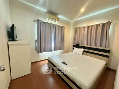 Cozy bedroom with modern furnishings and natural light, featuring a comfortable bed and stylish curtains.
