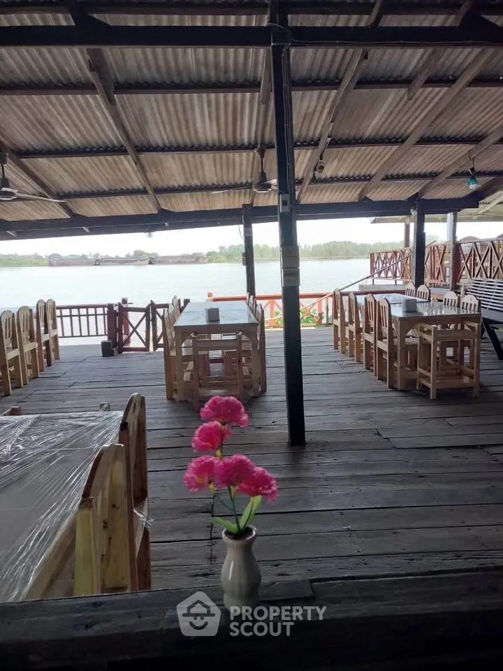 Charming riverside wooden deck with rustic dining setup and scenic water view.