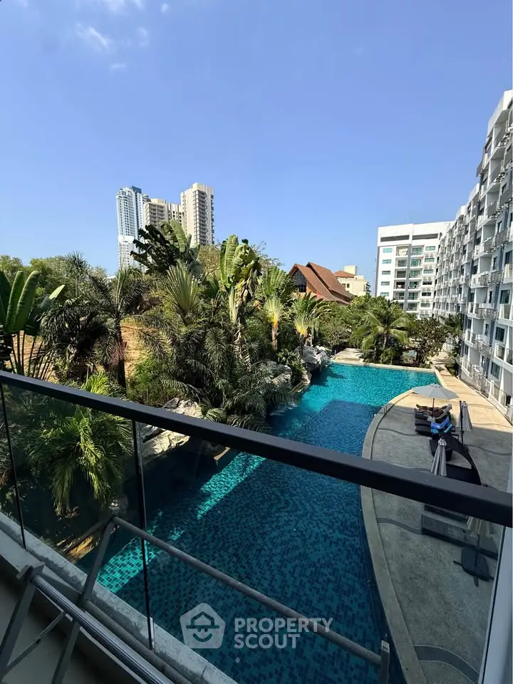 Luxurious poolside view from a modern apartment balcony with lush greenery and cityscape backdrop.