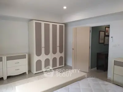 Spacious bedroom with modern furniture and ample storage space