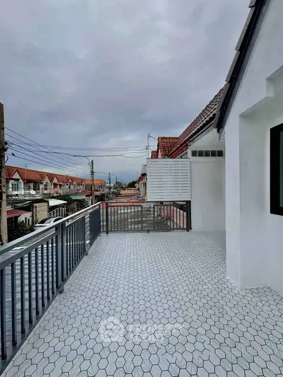 Spacious balcony with modern tiles offering a scenic neighborhood view, perfect for relaxation.