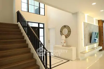 Elegant modern home interior with stylish staircase and wall-mounted TV