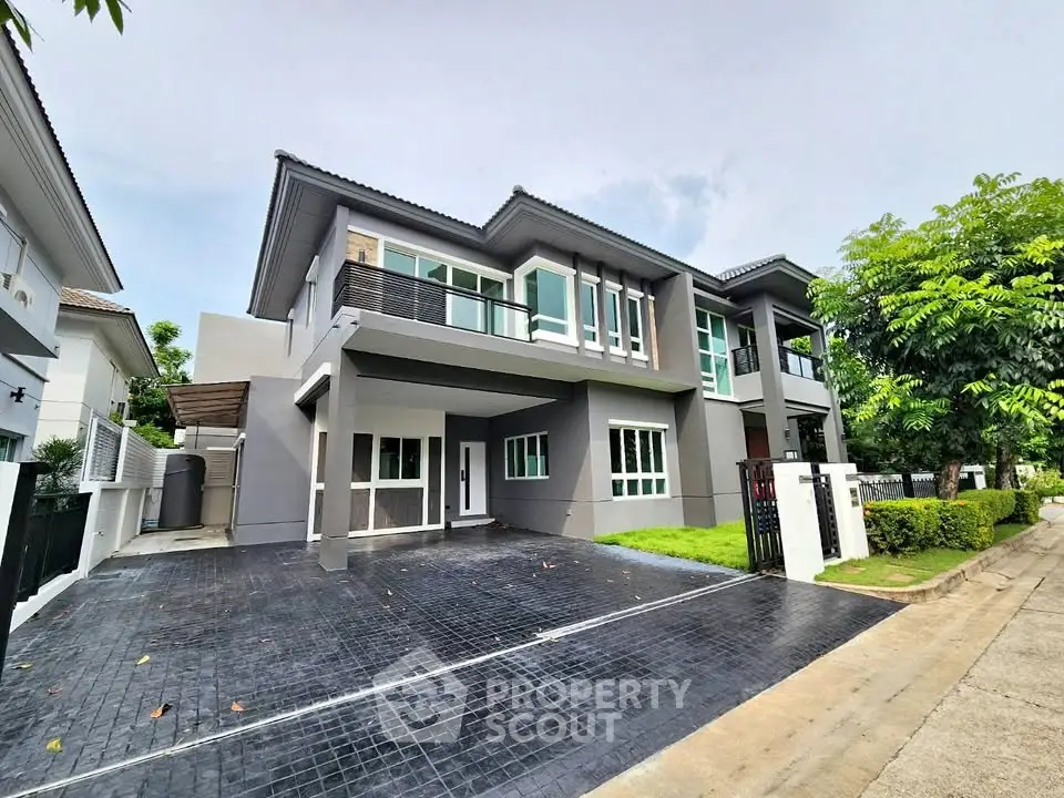 Modern two-story house with spacious driveway and lush greenery