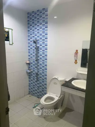 Modern bathroom with shower and toilet in a tiled setting