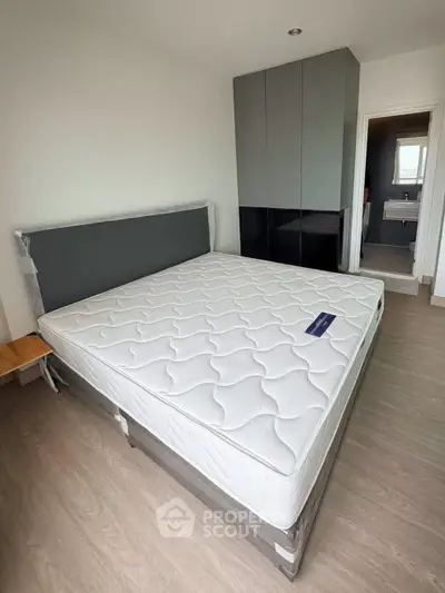 Spacious bedroom with modern design and large bed, featuring sleek wardrobe and natural light.
