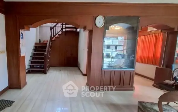 Spacious living area with wooden accents and staircase, ideal for family gatherings.