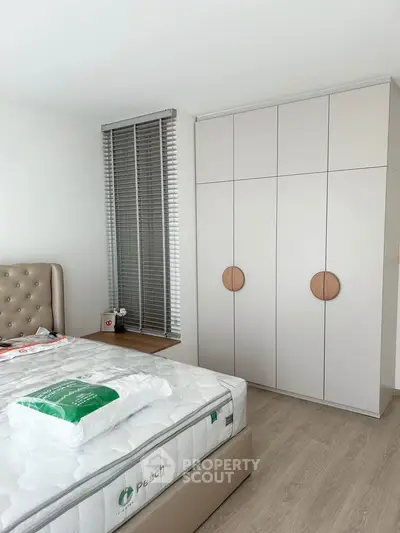 Modern bedroom with stylish wardrobe and cozy bed in a bright, minimalist design.