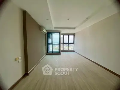Spacious empty living room with large windows and city view