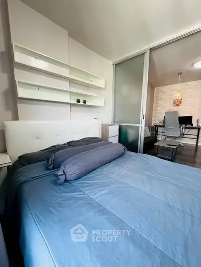 Modern bedroom with sliding glass door and cozy blue bedding