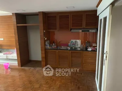 Spacious kitchen with wooden cabinets and parquet flooring in modern apartment