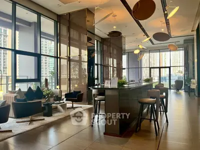 Luxurious modern living room with floor-to-ceiling windows and stylish decor in high-rise building.