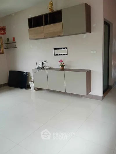 Spacious living room with modern cabinetry and sleek tile flooring, perfect for contemporary living.