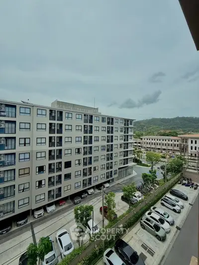 Modern apartment building with ample parking and scenic mountain views.