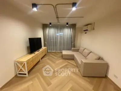 Modern living room with stylish wooden flooring and cozy sectional sofa.