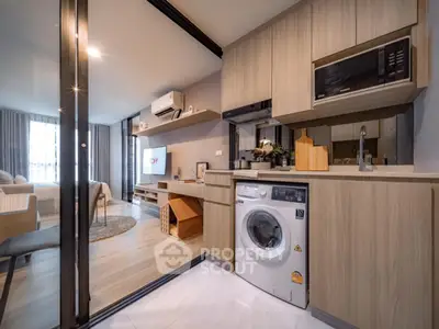 Modern open-plan kitchen with washing machine and cozy living area