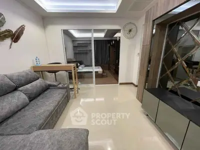 Modern living room with sleek furniture and open layout, featuring a cozy sofa and stylish decor.