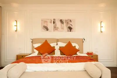 Luxurious bedroom with elegant decor and warm lighting, featuring a plush bed and stylish artwork.