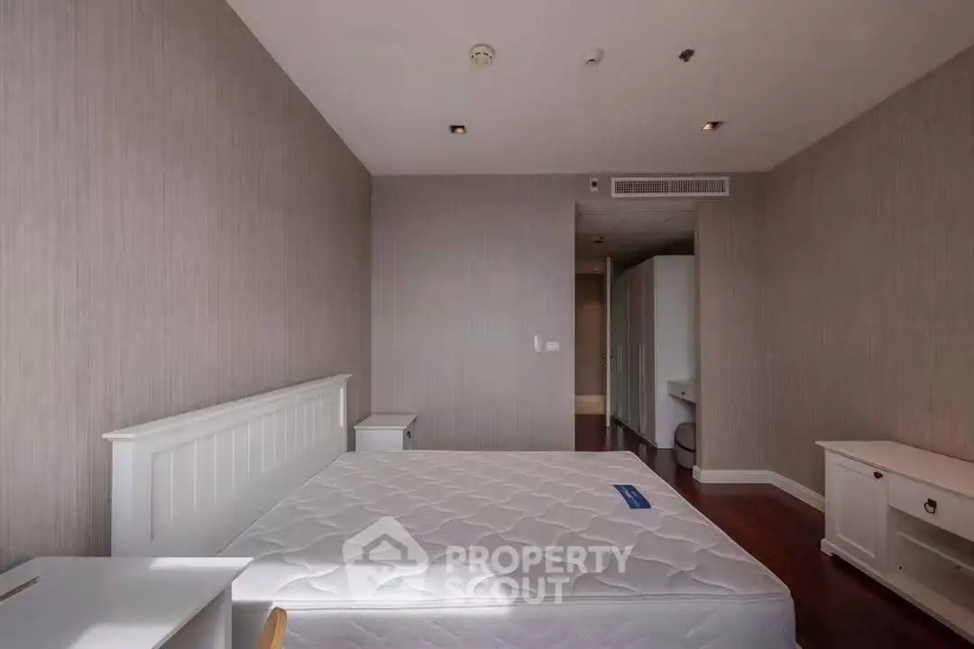 Spacious bedroom with modern decor and ample natural light, featuring a comfortable bed and stylish furnishings.