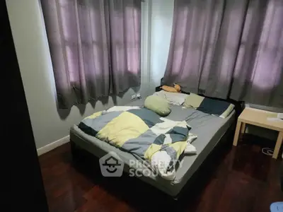 Cozy bedroom with wooden flooring and soft lighting, perfect for relaxation.