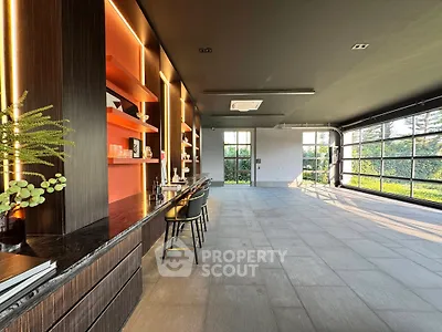 Spacious modern living room with large windows and stylish decor, perfect for entertaining.