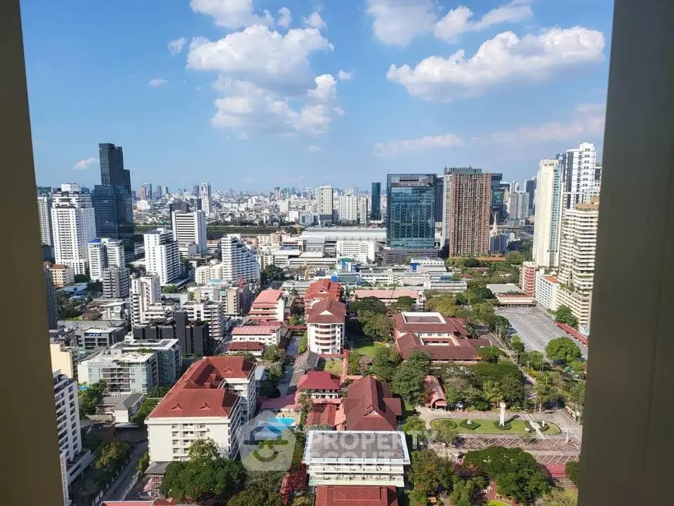 Stunning cityscape view from high-rise building showcasing urban skyline and greenery.