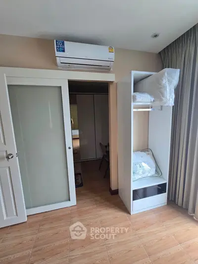 Cozy bedroom with air conditioning and ample storage space in modern apartment.