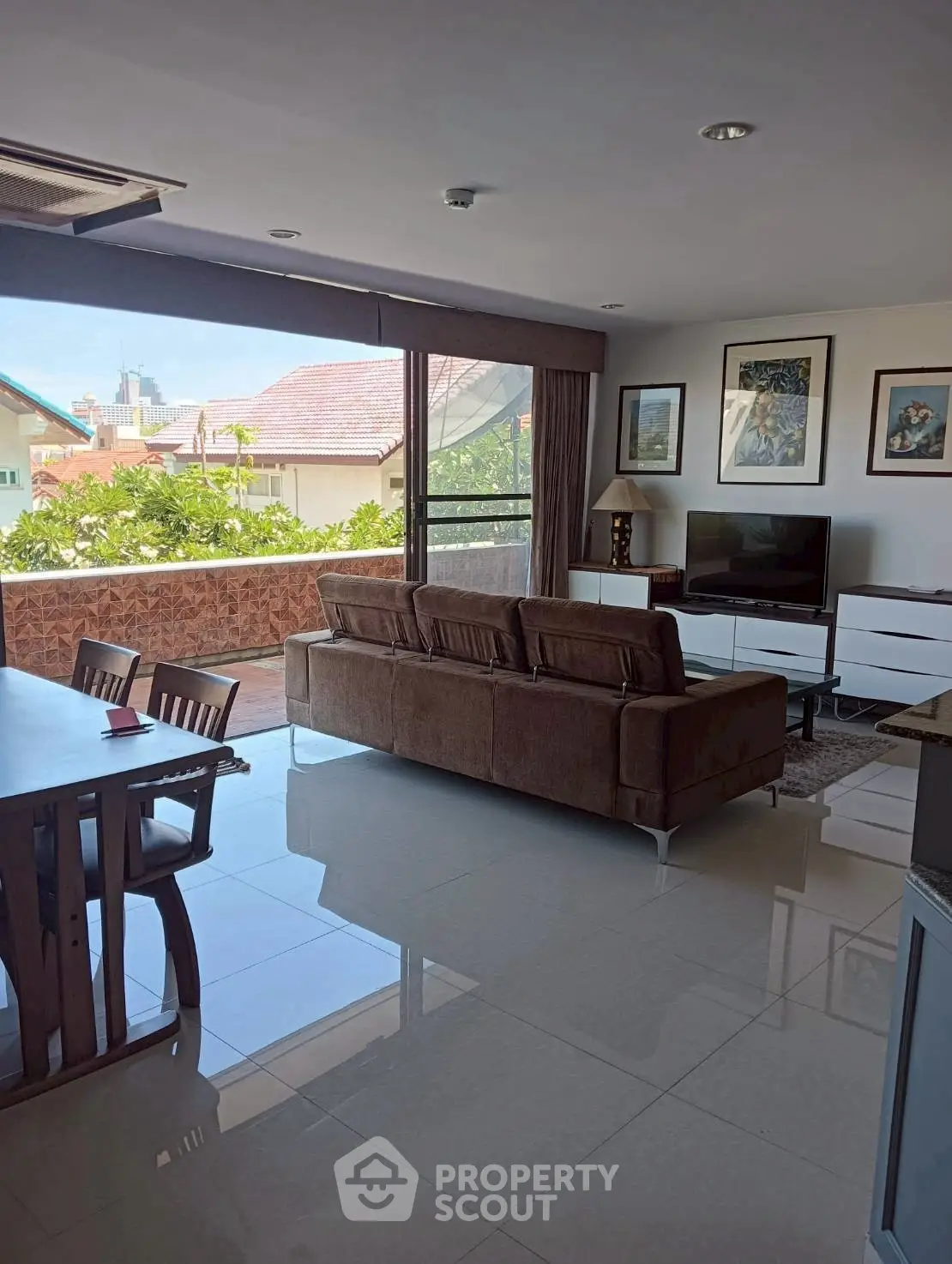 Spacious living room with large balcony and scenic view, perfect for relaxation and entertainment.