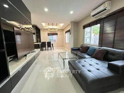 Spacious modern living room with sleek black furniture and large windows