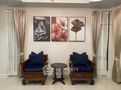 Elegant living room with stylish artwork and cozy seating area, perfect for relaxation and entertaining guests.