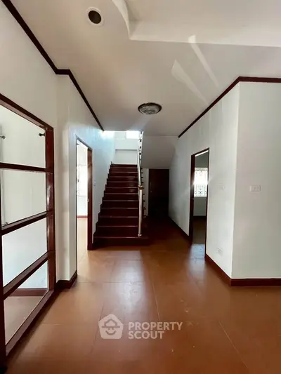 Spacious interior hallway with wooden staircase and natural light