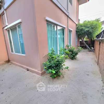 Charming corner unit with lush greenery and spacious exterior walkway.