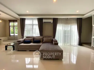 Spacious modern living room with large windows and elegant furnishings