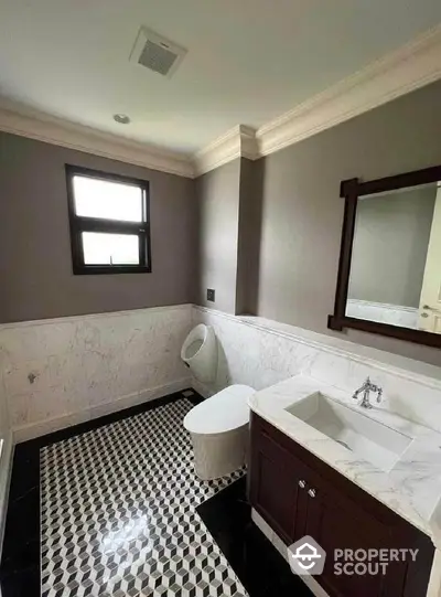 Elegant bathroom with modern fixtures and stylish black-and-white tile flooring.