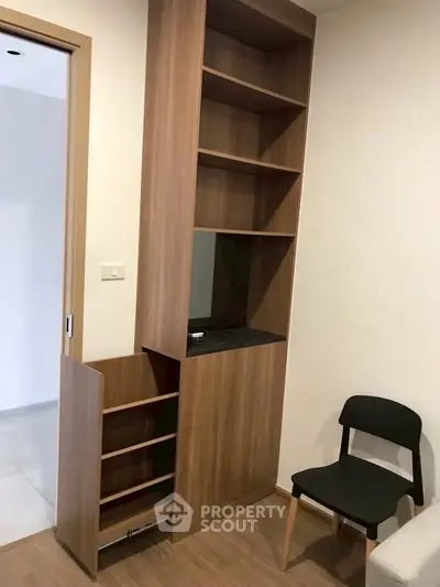 Modern interior with built-in wooden shelving and sleek chair in cozy living space.
