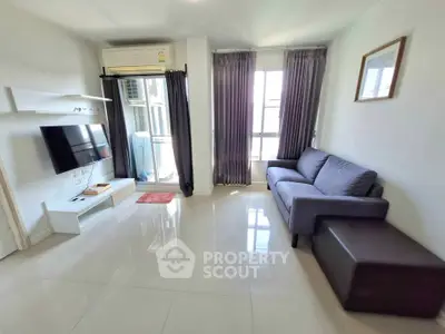 Modern living room with sleek furniture and natural light, featuring a cozy sofa and wall-mounted TV.