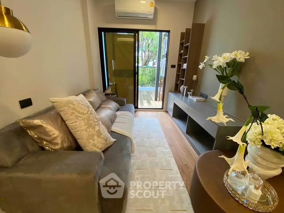 Stylish living room with cozy sofa and balcony view, perfect for relaxation.