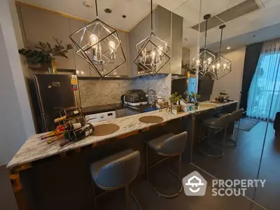 Chic modern kitchen with stylish pendant lighting and marble countertop island, featuring high-end appliances and open layout design, perfect for entertaining.