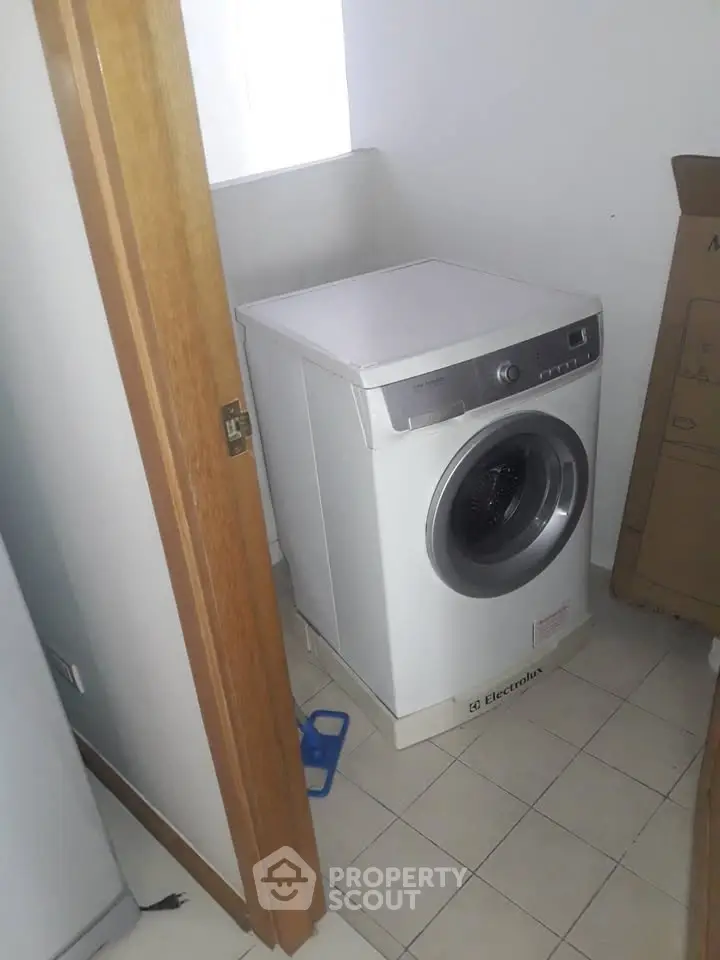 Compact laundry area with modern washing machine in a cozy home setting.